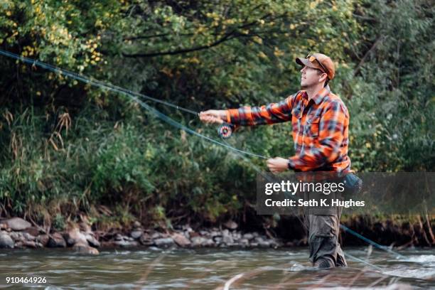 man wading in river, fishing - seth fisher stock pictures, royalty-free photos & images