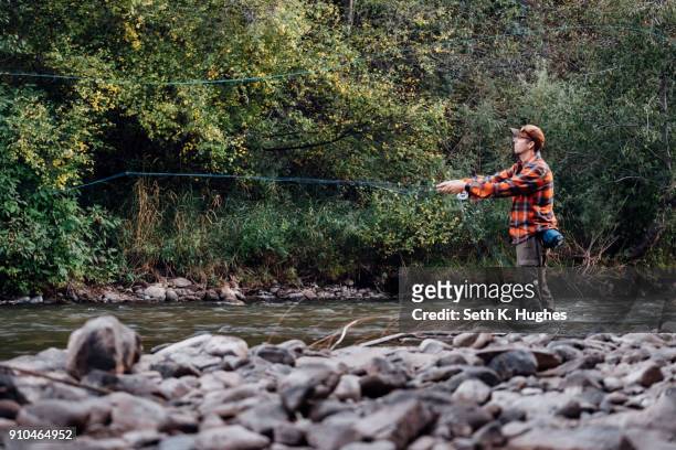 man wading in river, fishing - seth fisher stock pictures, royalty-free photos & images