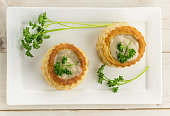 Puff pastry vol-au-vents filled with mushroom ragout on a white plate