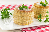 Puff pastry vol-au-vents filled with mushroom ragout, topped with fresh parsley