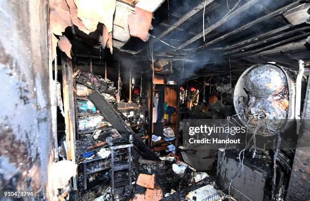 In this handout image provided by the Kyungnam Shinmun, Firefighter inspects a burnt hospital after a fire on January 26, 2018 in Miryang, South...