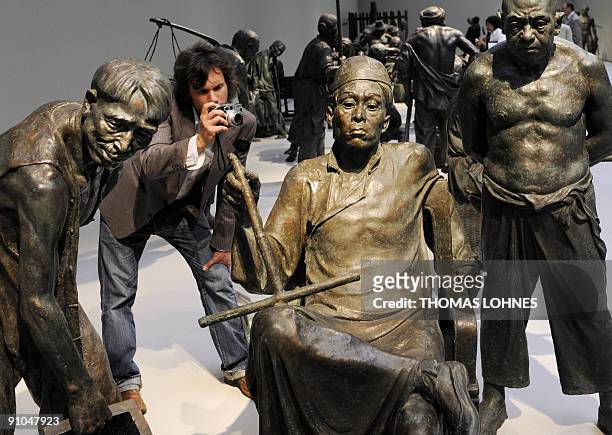 Man photographs sculptures of the exhibition "Art for millions - 100 sculptures from the Mao era" at the Schirm gallery in the central German city of...