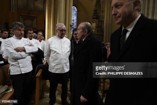 French Interior Minister Gerard Collomb walks past French chefs Regis Marcon (l0 and Alain Ducasse after delivering a speech during the funeral...