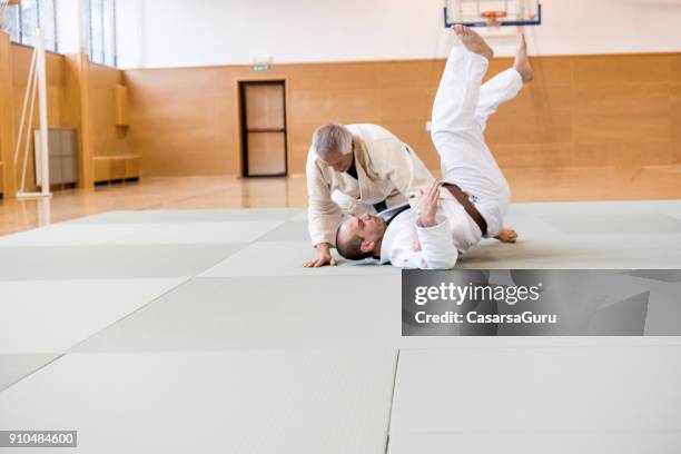 senior judokämpfer gedrückter seinen gegner - takedown stock-fotos und bilder