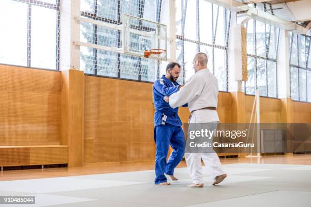 twee volwassen judo vechters in sportschool - asian indoor & martial arts games stockfoto's en -beelden