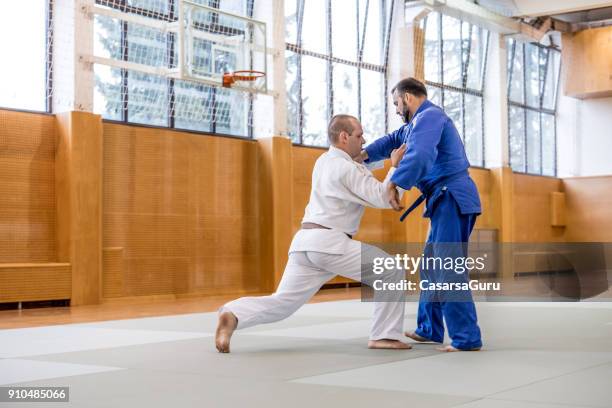 twee volwassen judo vechters in sportschool - asian indoor & martial arts games stockfoto's en -beelden