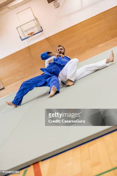 judoist holding zijn tegenstander op de grond - asian indoor & martial arts games stockfoto's en -beelden