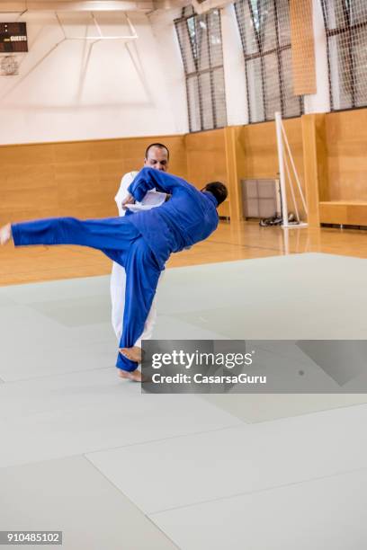 volwassen judoist met behulp van voet gooien techniek om te zetten van zijn tegenstander off balance - asian indoor & martial arts games stockfoto's en -beelden