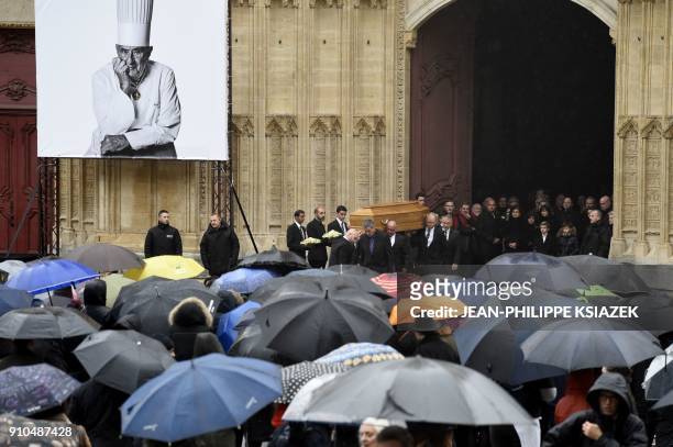 Poeple look at the coffin of French chef Paul Bocuse as it leaves the Saint-Jean Cathedral in Lyon on January 26, 2018 at the end of the funeral...