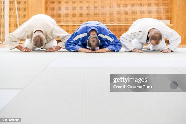 three people in kimono bowing down - tatami mat stock pictures, royalty-free photos & images