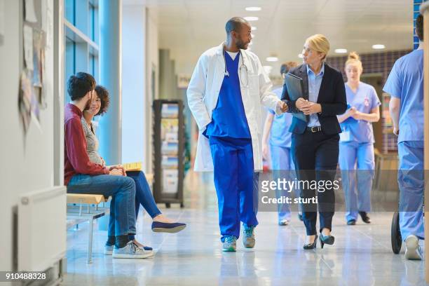 vertriebsmitarbeiter im krankenhaus - doctors walking stock-fotos und bilder