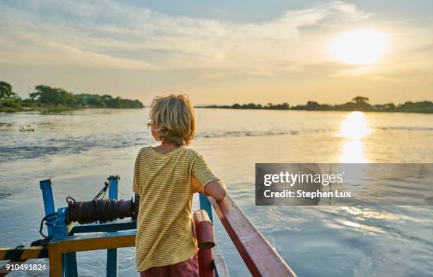 boy looking away at view of sunset over lake, bonito, mato grosso do sul, brazil, south america - マトグロッソドスル州 ストックフォトと画像