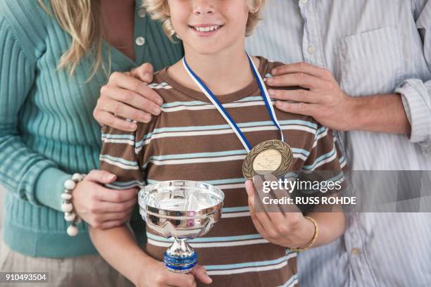 cropped view of boy proudly holding trophy and medal - awards day 3 stock pictures, royalty-free photos & images