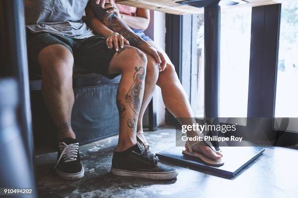 waist down of multi ethnic hipster couple in cafe with hand on each others knee, shanghai french concession, shanghai, china - hand on knee fotografías e imágenes de stock
