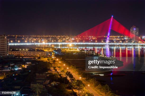 tran thi ly bridge in danang, vietnam crossing the han river, a cable-stayed suspension bridge displaying the colorful light at night - impossiable fotografías e imágenes de stock