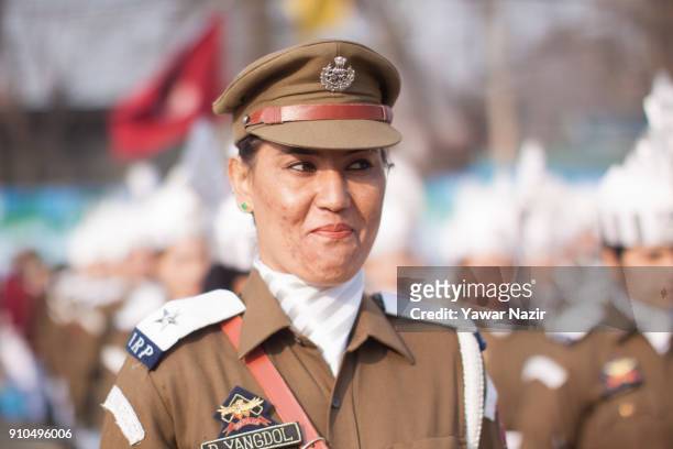 An Indian woman police officer smiles as she stands in formation at the Sher- i- Kashmir stadium, where the authorities held the main function during...