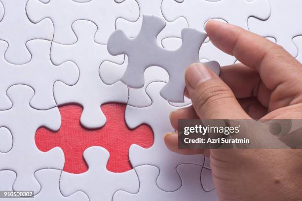 hand holding piece of blank jigsaw puzzle - interlocking fingers stock pictures, royalty-free photos & images