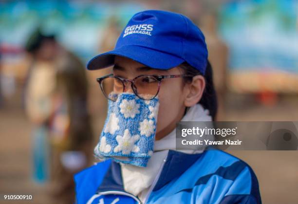 Kashmiri girl hides her face with handkerchief at the Sher- i- Kashmir stadium, as she participates in the parade, where the authorities held the...