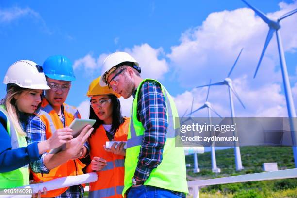 jonge ingenieurs die werkzaam zijn in windpark - adults only stockfoto's en -beelden