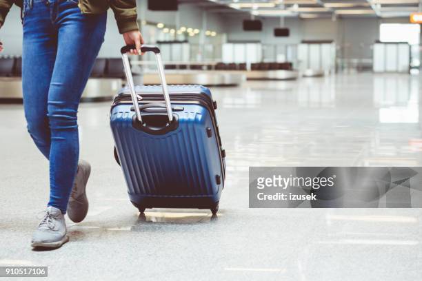woman walking with suitcase at airport terminal - suitcase stock pictures, royalty-free photos & images