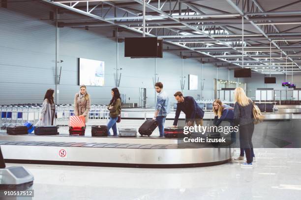 viajantes de avião à espera de bagagem perto de correia transportadora - área de retirada de bagagem - fotografias e filmes do acervo