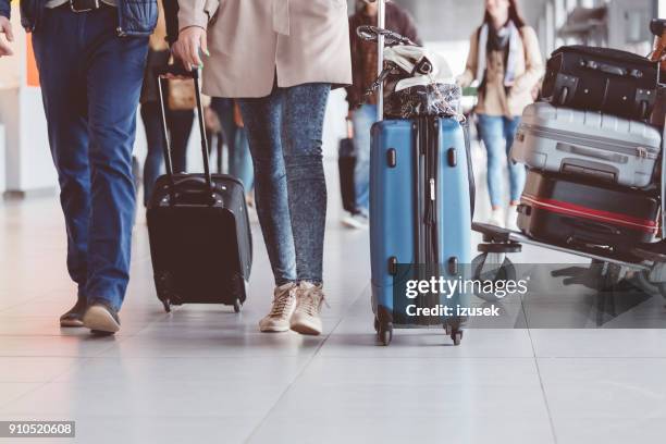 group of people walking with suitcase at airport terminal - airport crowd stock pictures, royalty-free photos & images