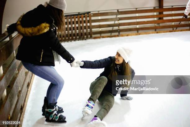 två vackra flickor som bär varma vinterkläder skridskoåkning - ice skate bildbanksfoton och bilder