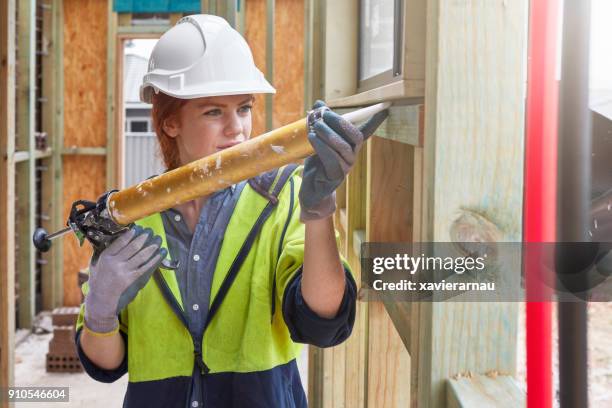 bauarbeiter mit fugenpistole auf fenster - caulk stock-fotos und bilder