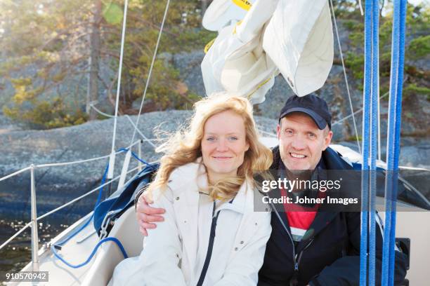 woman and man sitting in a sailingboat - sailingboat stock-fotos und bilder