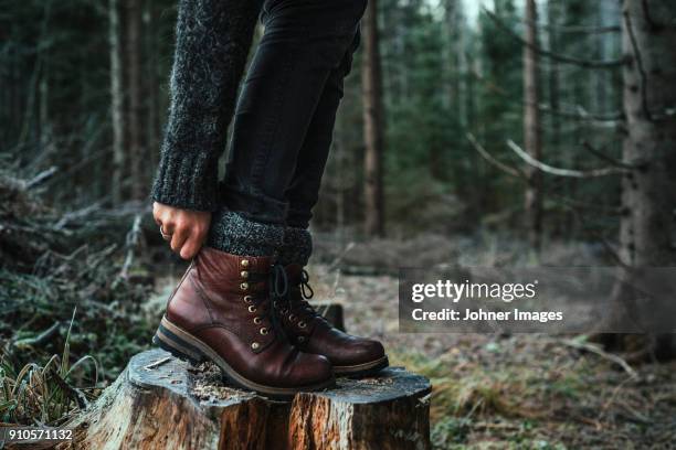 woman in boots standing on a stump - leather boot 個照片及圖片檔