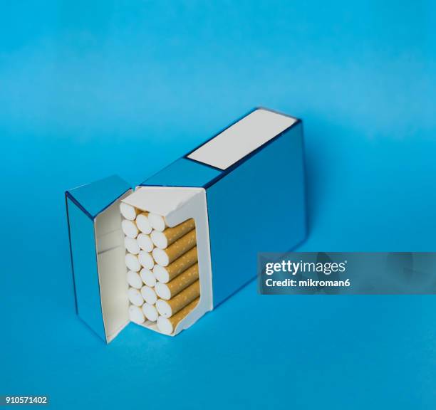 cigarette box and cigarettes on blue background - zigarettenfilter stock-fotos und bilder