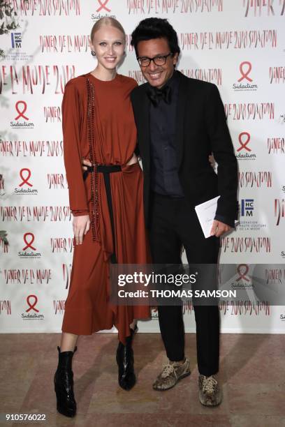 Lebanese businessman Omar Harfouch and Russian model Yulia Lobova pose upon arriving to the Diner de la Mode fundraiser dinner, to benefit the French...