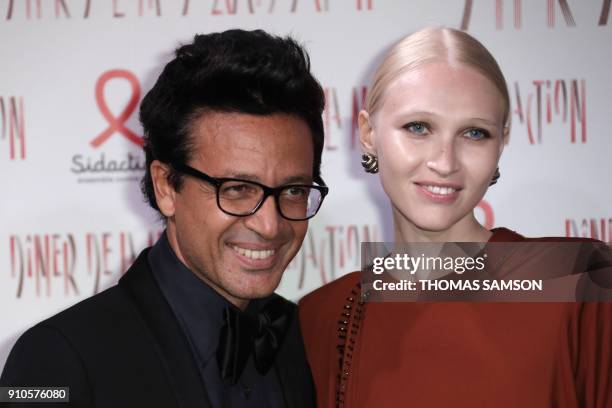 Lebanese businessman Omar Harfouch and Russian model Yulia Lobova pose upon arriving to the Diner de la Mode fundraiser dinner, to benefit the French...