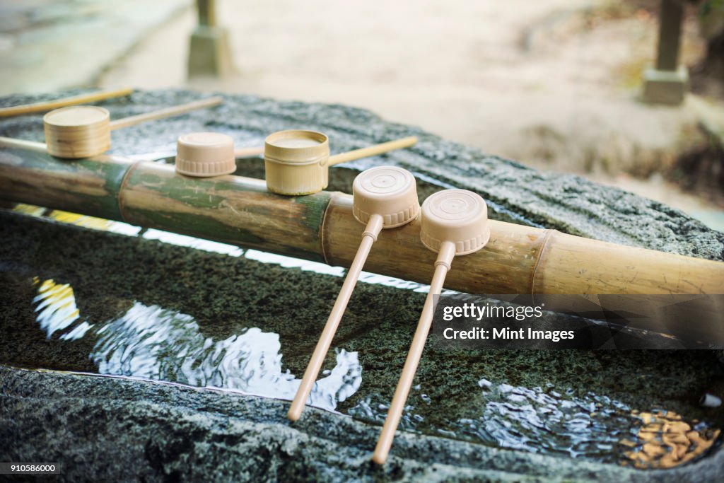 Close up of bamboo water hand washing basins at Shinto Sakurai Shrine, Fukuoka, Japan.