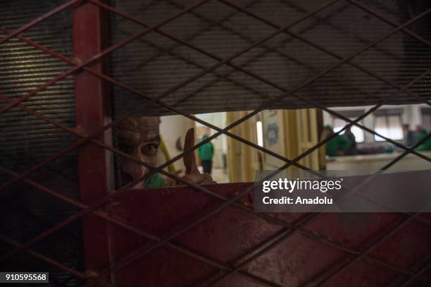 Man gestures at a psychiatric hospital, damaged in an artillery shooting by PYD/PKK terror groups in Afrin a week ago, in Azez region of Aleppo,...