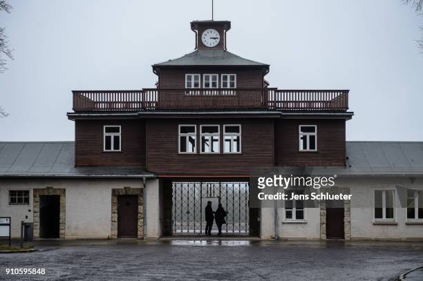 People stand in front of the former main entrance to the Buchenwald concentration camp on January 26, 2018 near Weimar, Germany. International...