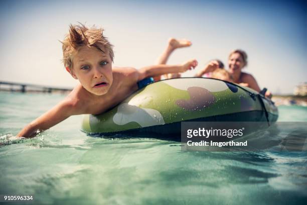 niño cae del barco inflable - bote neumático fotografías e imágenes de stock