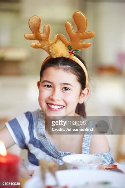 クリスマス ランチを楽しんでいる枝角を持つかなり若い混血の少女 - トリテレイアイキシオイデス ストックフォトと画像