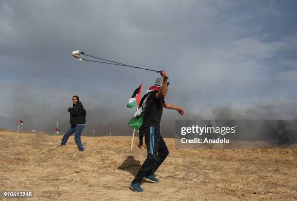 Palestinian protesters throw rocks in response to Israeli security forces' intervention during a protest against U.S. President Donald Trumps...