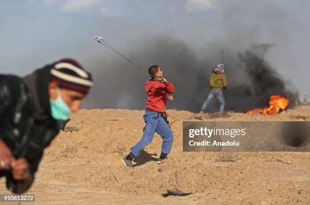 Palestinian protesters burn tyres and throw rocks in response to Israeli security forces' intervention during a protest against U.S. President Donald...
