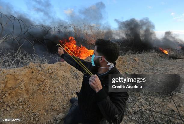 Palestinian protester throws a rock in response to Israeli security forces' intervention during a protest against U.S. President Donald Trumps...