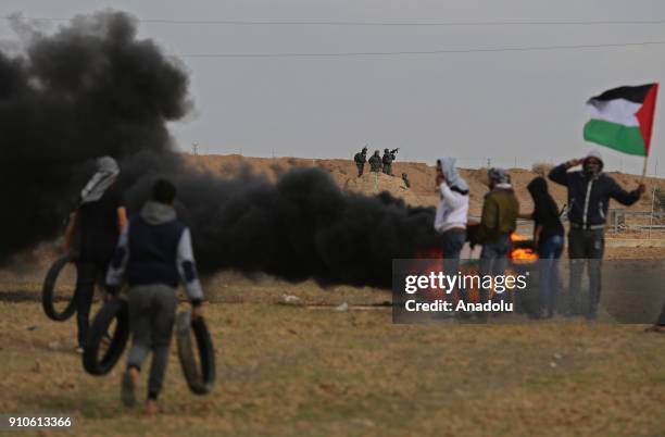 Palestinian protesters burn tyres and throw rocks in response to Israeli security forces' intervention during a protest against U.S. President Donald...