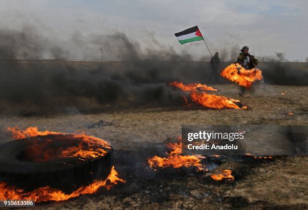 Palestinian protesters burn tyres and throw rocks in response to Israeli security forces' intervention during a protest against U.S. President Donald...