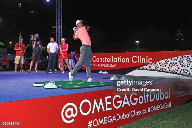 Rory McIlroy of Northern Ireland hits a shot watched by Niall Horan the music artist and Paige Spiranac of the United States at the Omega...