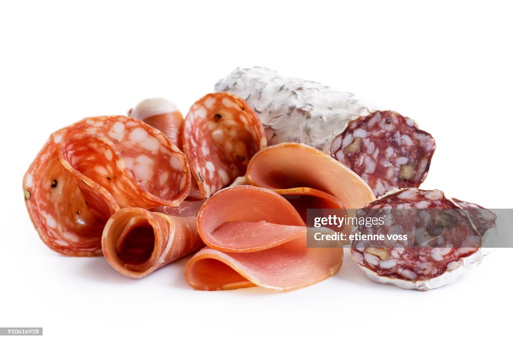 Mixed air cured sliced meats isolated on white.