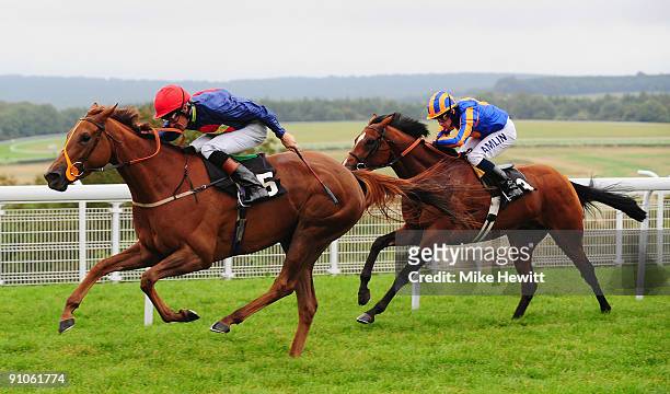 Richard Hughes on Fanditha is followed home by Ryan Moore on Plymouth Rock in the Piper Champagne Stakes at Goodwood racecourse on September 23, 2009...