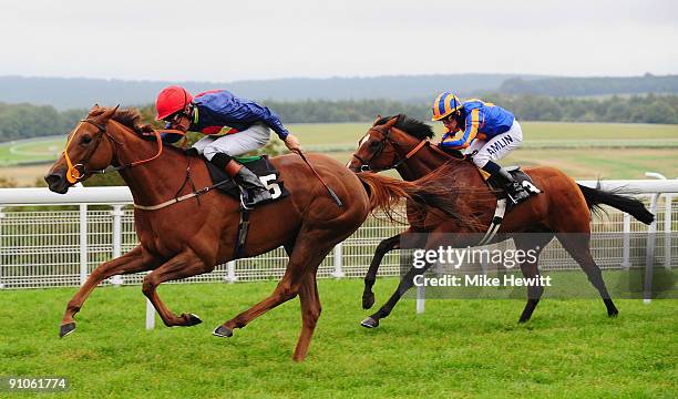 Richard Hughes on Fanditha is followed home by Ryan Moore on Plymouth Rock in the Piper Champagne Stakes at Goodwood racecourse on September 23, 2009...