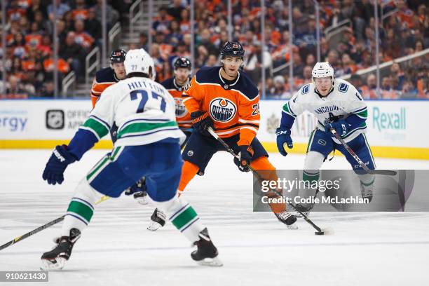 Darnell Nurse of the Edmonton Oilers is watched by Ben Hutton and Brock Boeser of the Vancouver Canucks at Rogers Place on January 20, 2018 in...