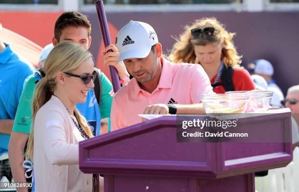 Paige Spiranac of tThe United States working as the official starter on the first tee gives Sergio Garcia of Spain his scorecard during the second...