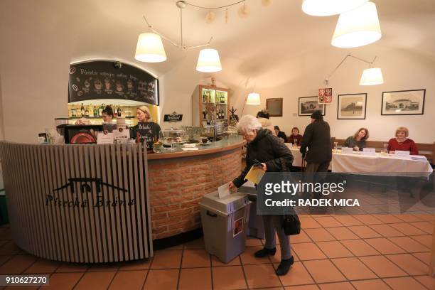 Woman casts her ballot in the coffee-bar Pisecka Brana, transformed as pooling station in Prague-Dejvice, on January 26, during the second round of...